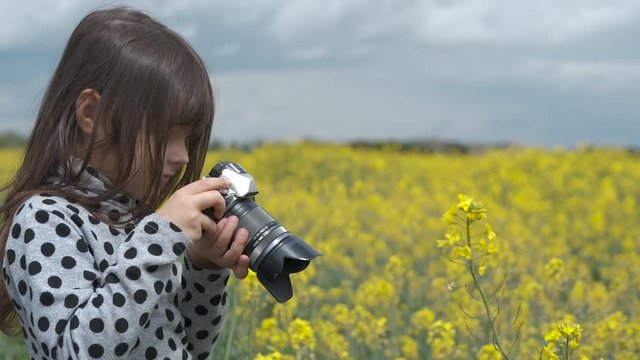 Young photographer. Cute little girl with a camera in nature.