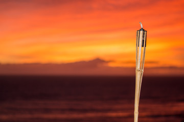 Citronella oil lamp burning at sunset