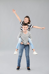 Happy children in jeans on grey background