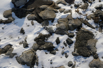 graue steine und schnee an der nordsee küste