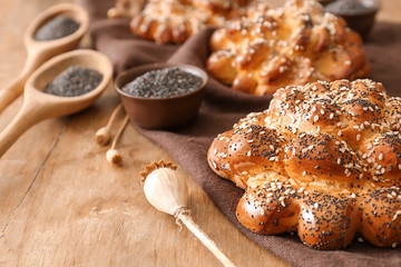 Tasty buns with poppy seeds on table