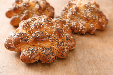 Tasty buns with poppy seeds on table