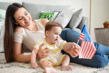 Mother and her little baby with national flag of USA at home