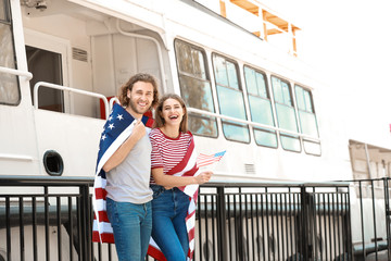 Happy young couple with USA flag on embankment. Independence Day celebration