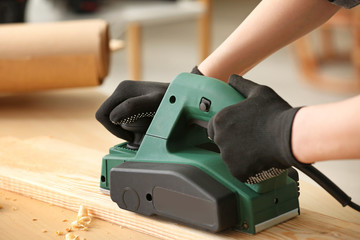 Female carpenter working in shop, closeup