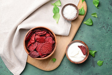 Tasty beet chips with sauce on table