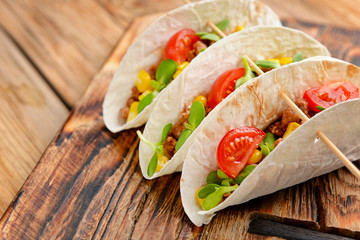 Tasty fresh tacos on wooden  table