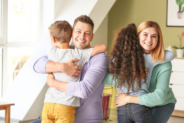 Happy couple with little adopted children at home