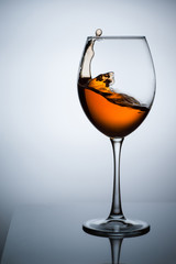 Amber wine. A splash of wine in a glass. Liquid in a glass. Traditional wine according to the ancient Georgian technology. Concept with a glass of wine. Copy space. Close up and vertical orientation.