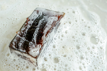 soap with tea tree oil on the background of soap suds