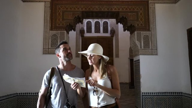 Couple walking through La Bahia Palace with city map