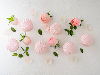 Delicate buds of pink roses and airy marshmallows. Flat Lay. Copy space.