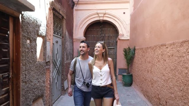 Cheerful couple walking through traditional Moroccan streets
