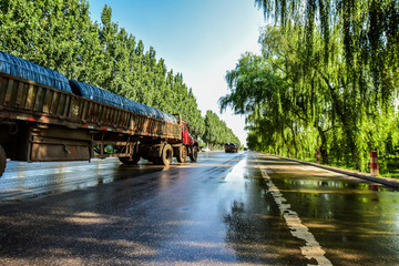 Fototapeta na wymiar Transport trucks on the tarmac road after the rain