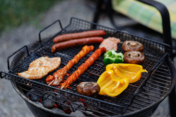 Grillplatte mit Fleischspießen Paprika und Pilzen auf Kugelgrill