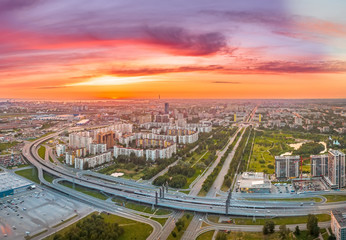 Bright sunset over the city c with highway and bridge, aerial view from a height.