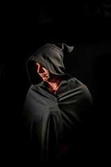 Fototapeta na wymiar Portrait of a courageous warrior wanderer in a black cloak. Historical fantasy. Halloween.