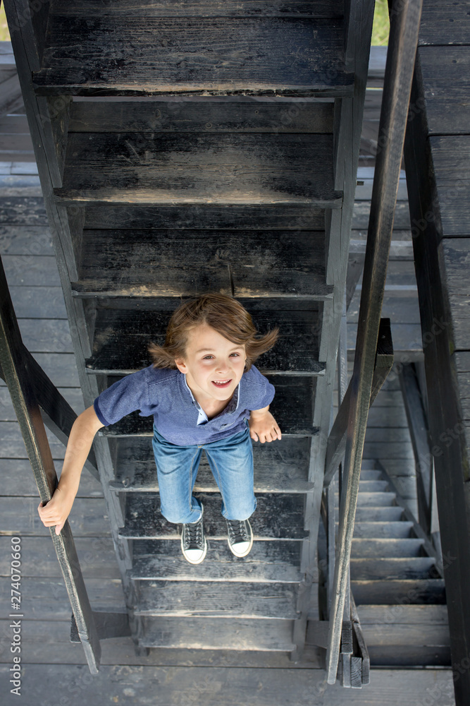 Wall mural Child, preteen boy, sitting on wooden stairs