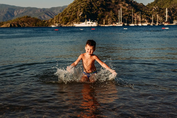 Fototapeta premium Five-year-old child splashes water into the sea