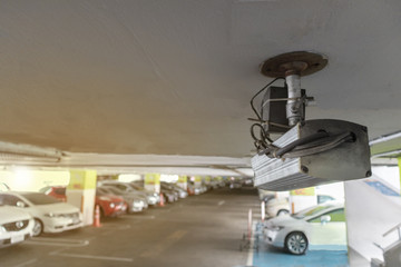 Naklejka premium CCTV security camera in parking lot security cars. Security Concept.