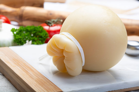 Italian provolone or provola caciocavallo hard cheese in teardrop form served on white marble plate close up