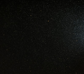 Snow flies in the sky at night as a background