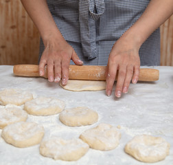 Girl rolls the dough in the kitchen
