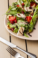 Tasty and healthy salad with arugula, brie, cheese, avocado, cherry tomatoes, dry cranberry and cashews. Top view. The flat lay. Banner