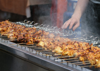 Preparing meats on barbecue.