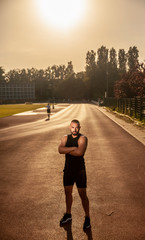 one young man, powerful athlete posing, looking to camera.