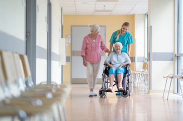 Elderly woman on wheelchair with her daughter and nurse