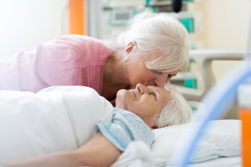 Daughter visiting her senior mother in hospital