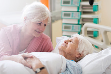 Daughter visiting her senior mother in hospital