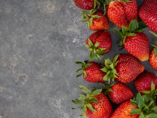 Fresh red strawberries on a gray background with copy space. Top view.