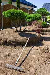 Making new home garden decorations, planting evergreen trees and creating decorative stone bed.
