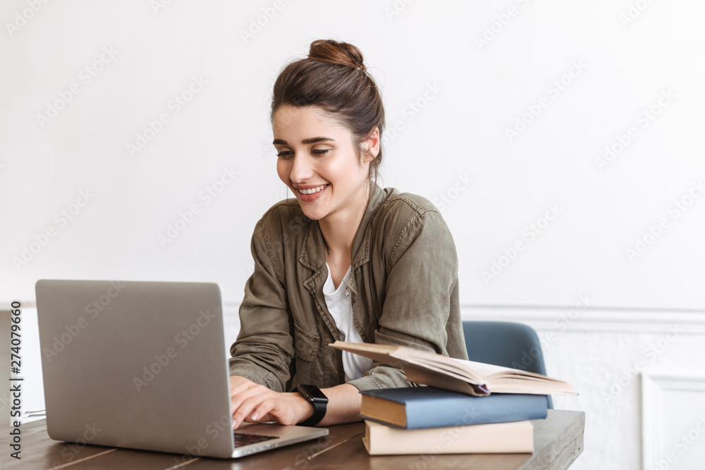 Wall mural Young happy woman using laptop computer indoors,