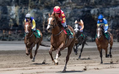 Foto op Plexiglas Close up on lead race horse and jockey galloping towards the finish line, race horse action on the beach © Gabriel Cassan