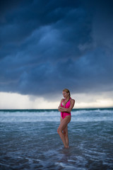 Fitness model on the beach at storm