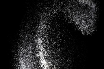 White powder splash isolated on black background. Flour sifting on a black background. Explosive powder white