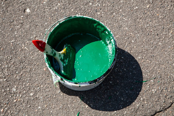 Paint brush. Bucket with green paint for painting wood. We begin to repair and ennoble the park....