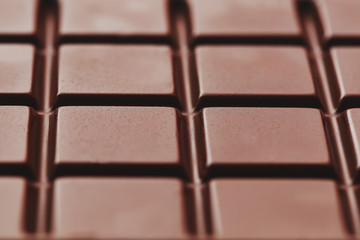 Texture of dark chocolate close up. Segments of a chocolate bar in macro. Full frame texture