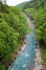 Scenery of shirahige's waterfall and Biei river. The water of this river flows into the blue pond at the downstream. Biei Hokkaido, Japan