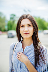 A girl of Asian appearance on a city street. Summer portrait of young Tatar on a blurred background