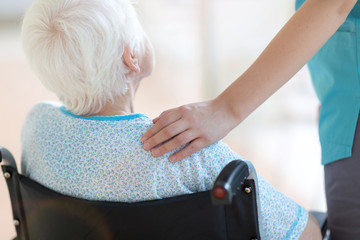 Senior woman in wheelchair with doctor in hospital