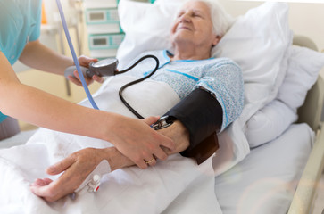 Senior patient and nurse in hospital