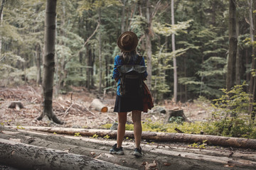 Style girl in hat with backpack in a summer time Mixed coniferous forest