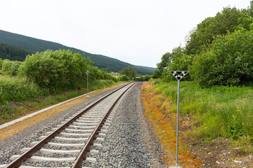 Fototapeta na wymiar Railway tracks in a rural scene with nice pastel sunset