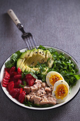 Tuna strawberry avocado egg and spinach salad in bowl - healthy food
