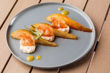 Grilled tiger shrimps with honey rear and cream cheese. Grilled seafood. On wooden background.