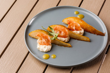 Grilled tiger shrimps with honey rear and cream cheese. Grilled seafood. On wooden background.